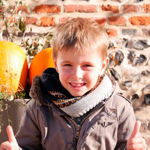 Un POPKid sourit, pouces levés